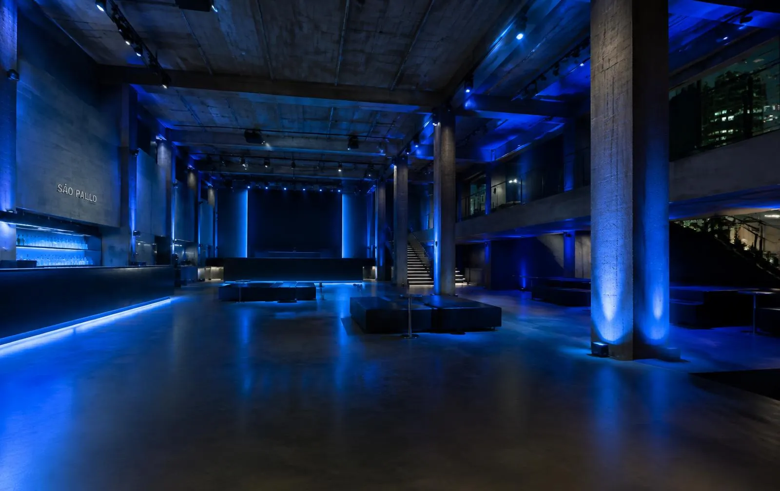 Interior do Pavilhão Singular em concreto aparente com luz azul